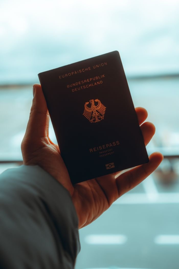 Home Close-up of a person holding a German passport, ideal for travel themes.